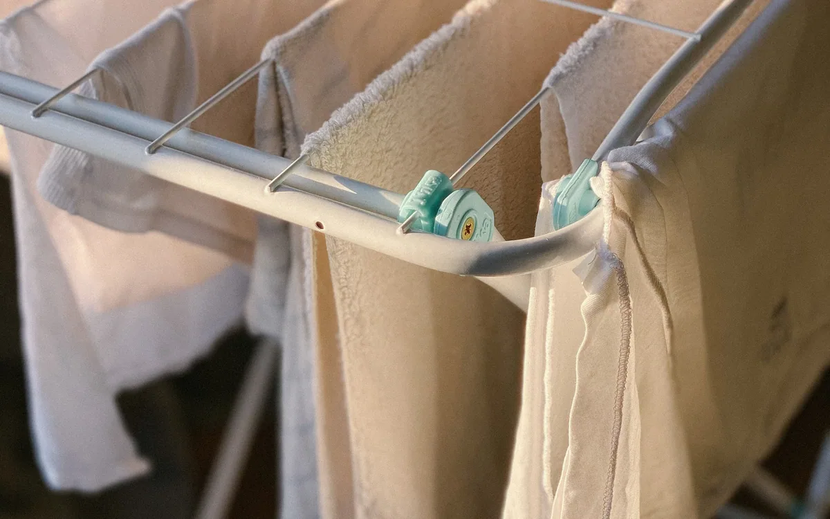 Light clothing and towels hanging on an indoor drying rack.