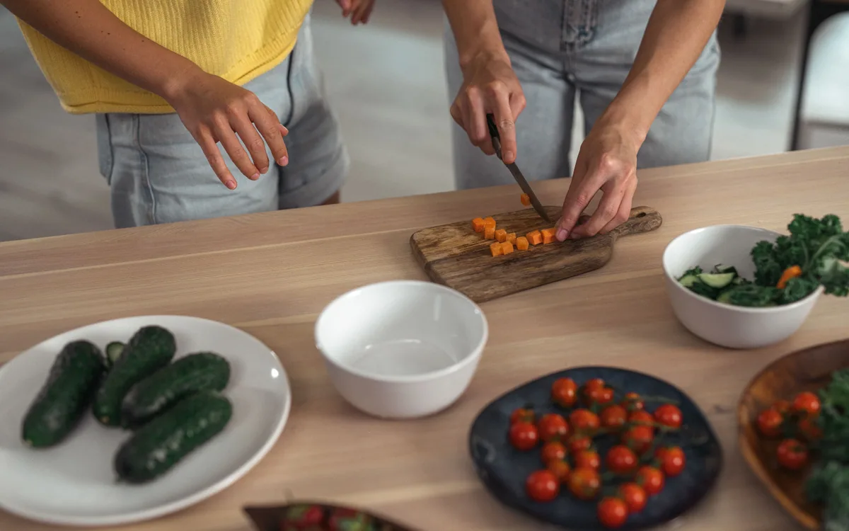 Vegetables, bowls, and a cutting board arranged on a kitchen worktop.