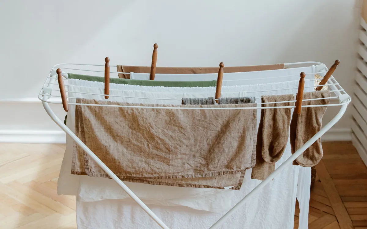 Laundry spread over an indoor drying rack in sunlight.