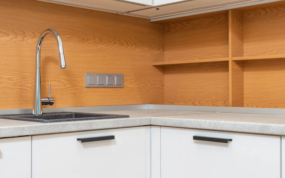 A kitchen sink above wooden base cabinets.