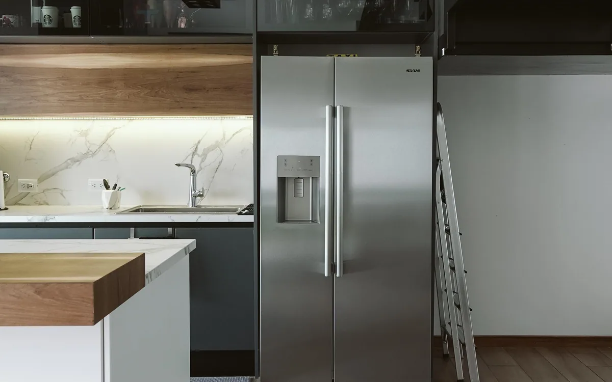 A refrigerator and built-in appliances in a light kitchen.